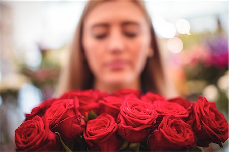 simsearch:6109-08700690,k - Female florist holding bunch of rose flowers in the flower shop Foto de stock - Sin royalties Premium, Código: 6109-08700638