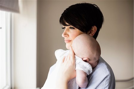 simsearch:6109-08700736,k - Mother standing near window holding her baby at home Foto de stock - Sin royalties Premium, Código: 6109-08700761