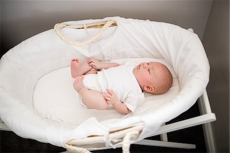 Newborn baby sleeping in moses basket at home Stock Photo - Premium Royalty-Free, Code: 6109-08700767