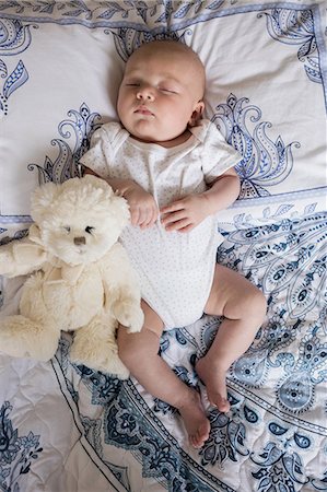 Baby sleeping on bed with teddy bear in bedroom at home Stock Photo - Premium Royalty-Free, Code: 6109-08700775