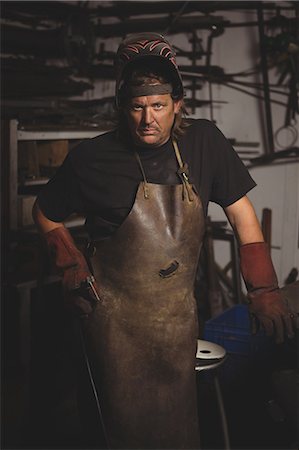 simsearch:6109-08722814,k - Portrait of blacksmith standing in workshop Foto de stock - Royalty Free Premium, Número: 6109-08700799