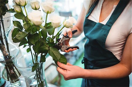 simsearch:6113-08536191,k - Mid section of female florist trimming flower leaf at her flower shop Stock Photo - Premium Royalty-Free, Code: 6109-08700709
