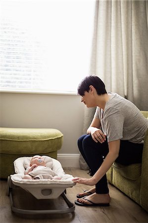 simsearch:6109-08537057,k - Mother sitting on sofa looking at her baby in living room at home Stock Photo - Premium Royalty-Free, Code: 6109-08700739