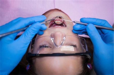 simsearch:6109-08700876,k - Dentist examining a young patient with tools at dental clinic Foto de stock - Royalty Free Premium, Número: 6109-08700876