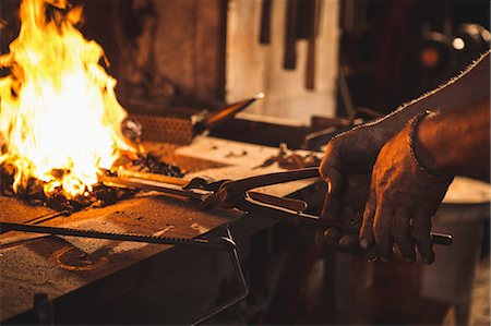 simsearch:6109-08700813,k - Close-up of blacksmith heating item before forging at work shop Photographie de stock - Premium Libres de Droits, Code: 6109-08700811