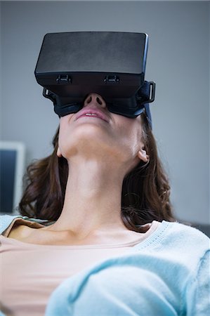 fone de ouvido - Woman using virtual reality in clinic Foto de stock - Royalty Free Premium, Número: 6109-08700823