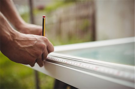 Close-up of carpenter's hands measuring a door frame Stock Photo - Premium Royalty-Free, Code: 6109-08700943