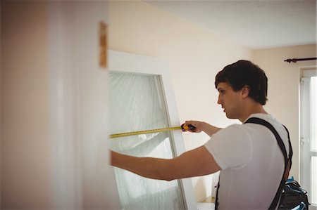 simsearch:6109-08536983,k - Carpenter measuring a door at home Foto de stock - Sin royalties Premium, Código: 6109-08700940