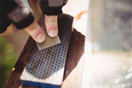 simsearch:6102-08995022,k - Close-up of carpenter's hand sharpening chisel on stone Photographie de stock - Premium Libres de Droits, Code: 6109-08700960