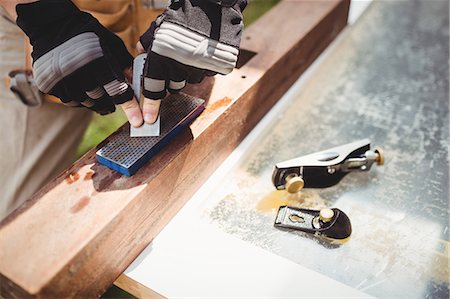 simsearch:6102-08995022,k - Close-up of carpenter's hand sharpening chisel on stone Photographie de stock - Premium Libres de Droits, Code: 6109-08700961
