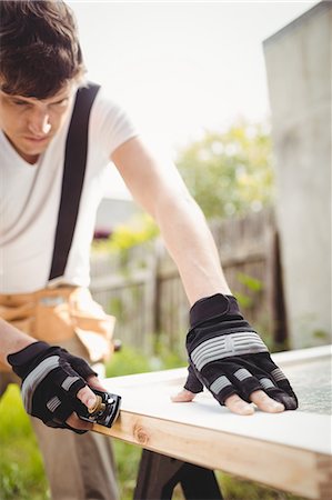 simsearch:6109-08700955,k - Carpenter leveling a wooden frame with block plane outside a house Fotografie stock - Premium Royalty-Free, Codice: 6109-08700965