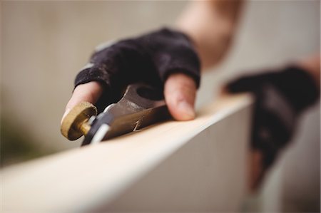 simsearch:6109-08700955,k - Close-up of carpenter's hand leveling a wooden frame with block plane Fotografie stock - Premium Royalty-Free, Codice: 6109-08700968