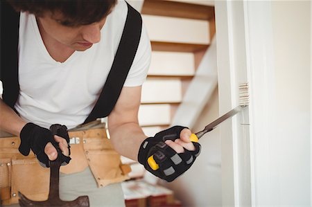 simsearch:6109-08537520,k - Carpenter working on a door frame at home Stock Photo - Premium Royalty-Free, Code: 6109-08700987