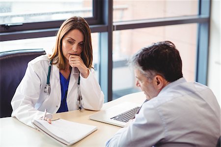 simsearch:6109-06006647,k - Female doctor at her desk talking to patient in the hospital Stock Photo - Premium Royalty-Free, Code: 6109-08701345