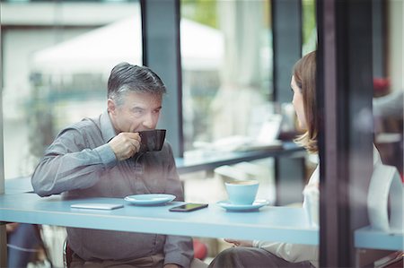 simsearch:6109-08701388,k - Man and woman having coffee in the cafeteria Foto de stock - Sin royalties Premium, Código: 6109-08701372