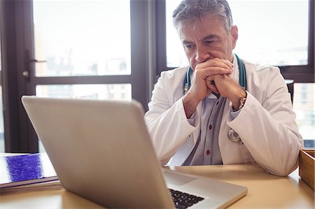 simsearch:400-07334526,k - Doctor using laptop at his desk at the hospital Photographie de stock - Premium Libres de Droits, Code: 6109-08701334