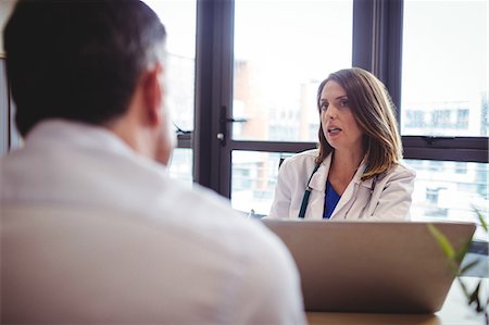 doctor consulting patient with medicine - Female doctor at his desk talking to patient in the hospital Stock Photo - Premium Royalty-Free, Code: 6109-08701339