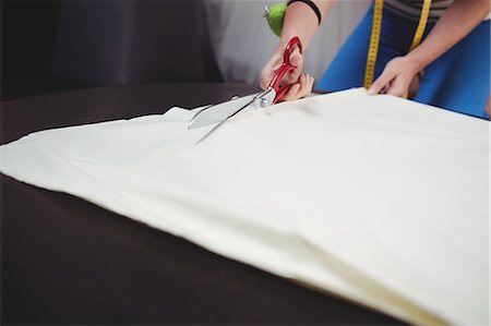 Female fashion designer cutting a white fabric in the studio Photographie de stock - Premium Libres de Droits, Code: 6109-08701443