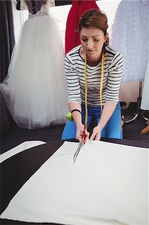 simsearch:6109-08701546,k - Female fashion designer cutting a white fabric in the studio Foto de stock - Sin royalties Premium, Código: 6109-08701442