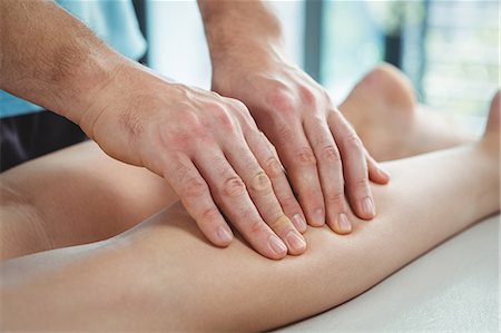 simsearch:6109-08701718,k - Close-up of physiotherapist giving physical therapy to the leg of a female patient in the clinic Foto de stock - Royalty Free Premium, Número: 6109-08701675