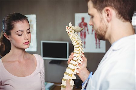 Physiotherapist explaining the spine to female patient in the clinic Foto de stock - Sin royalties Premium, Código: 6109-08701679