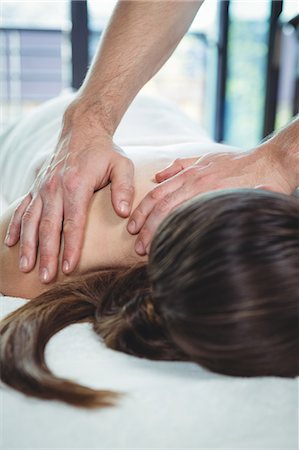 simsearch:6109-08701718,k - Physiotherapist giving physical therapy to the back of a female patient in the clinic Stock Photo - Premium Royalty-Free, Code: 6109-08701689