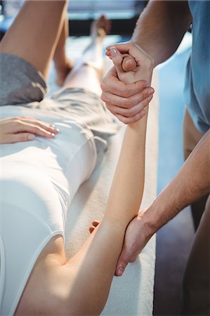Male physiotherapist giving arm massage to female patient in clinic Photographie de stock - Premium Libres de Droits, Code: 6109-08701617