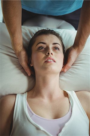 Male physiotherapist giving head massage to female patient in clinic Photographie de stock - Premium Libres de Droits, Code: 6109-08701631