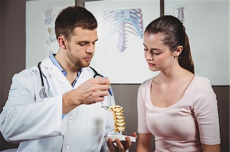 professional woman talking to patient - Physiotherapist explaining the spine to female patient in the clinic Stock Photo - Premium Royalty-Free, Code: 6109-08701748