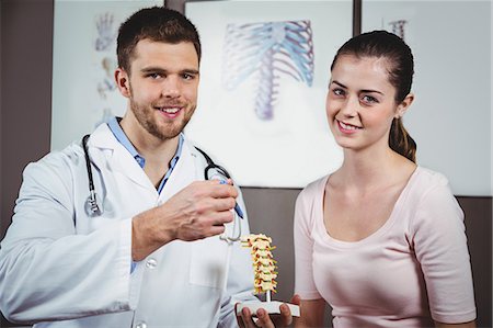 Portrait of physiotherapist explaining the spine to female patient in the clinic Photographie de stock - Premium Libres de Droits, Code: 6109-08701750