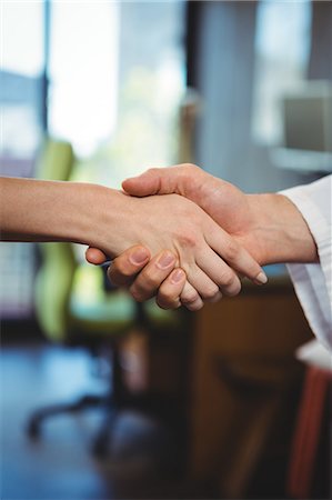 Close-up of physiotherapist shaking hands with female patient in the clinic Stock Photo - Premium Royalty-Free, Code: 6109-08701751