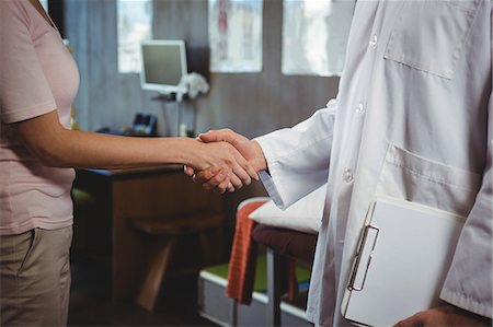 simsearch:6109-08701709,k - Mid section of physiotherapist shaking hands with female patient in the clinic Photographie de stock - Premium Libres de Droits, Code: 6109-08701752
