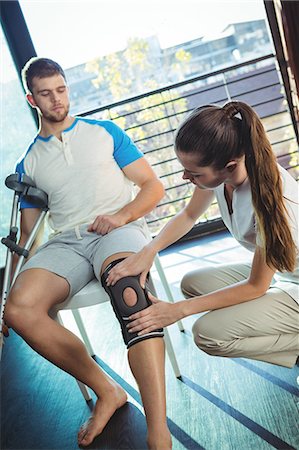 doctor with patient - Female physiotherapist examining his patient's knee in the clinic Photographie de stock - Premium Libres de Droits, Code: 6109-08701720