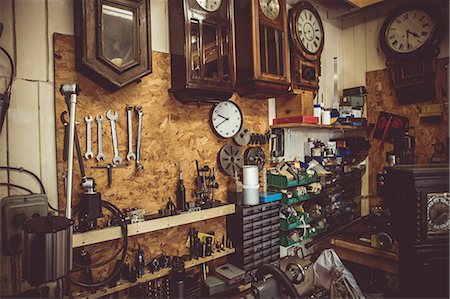 relojero (hombre y mujer) - Old horologists workshop with clock repairing tools, equipments and clocks on the wall Foto de stock - Sin royalties Premium, Código: 6109-08705152