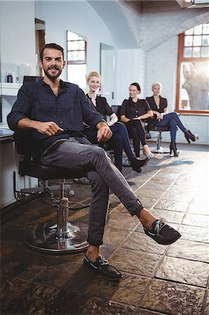 simsearch:6109-08705216,k - Portrait of smiling hairdressers sitting on chair in salon Stock Photo - Premium Royalty-Free, Code: 6109-08705219