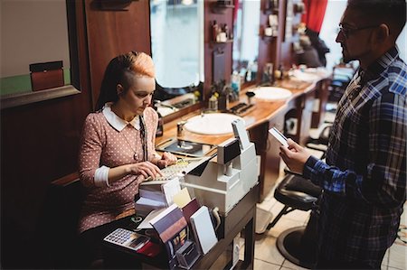 Man making payment with his credit card in barber shop Photographie de stock - Premium Libres de Droits, Code: 6109-08705365