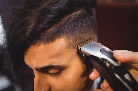 simsearch:6109-08705277,k - Man getting his hair trimmed with trimmer in barber shop Foto de stock - Royalty Free Premium, Número: 6109-08705379