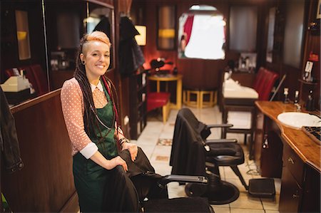 female hair stylist with apron - Portrait of smiling female barber standing in barber shop Stock Photo - Premium Royalty-Free, Code: 6109-08705393