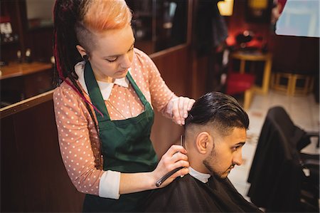styling hair - Man getting his hair trimmed with razor in barber shop Photographie de stock - Premium Libres de Droits, Code: 6109-08705392