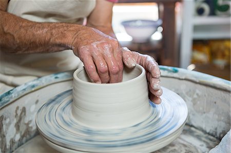 Mid section of potter making pot in pottery workshop Foto de stock - Sin royalties Premium, Código: 6109-08705469