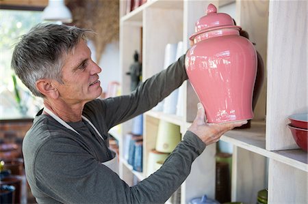 simsearch:6109-08705486,k - Close-up of male potter placing pot on shelf in pottery workshop Photographie de stock - Premium Libres de Droits, Code: 6109-08705490