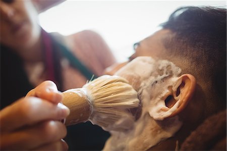 simsearch:6109-08705418,k - Man getting his beard shaved with shaving brush in barber shop Foto de stock - Sin royalties Premium, Código: 6109-08705407