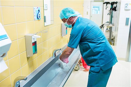simsearch:6109-08720095,k - Surgeon washing their hands at washbasin in hospital Stock Photo - Premium Royalty-Free, Code: 6109-08720096