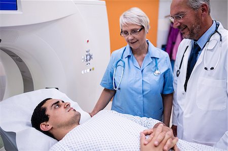 simsearch:6109-08720161,k - Doctors interacting with patient in scanning room at hospital Photographie de stock - Premium Libres de Droits, Code: 6109-08720152