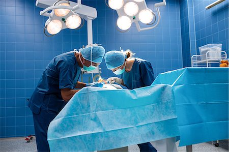 simsearch:400-06734621,k - Surgeons performing operation in operation room at the hospital Stock Photo - Premium Royalty-Free, Code: 6109-08720168