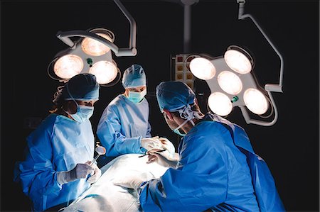 simsearch:6109-08830118,k - Surgeons performing operation in operation room at the hospital Foto de stock - Sin royalties Premium, Código: 6109-08720178