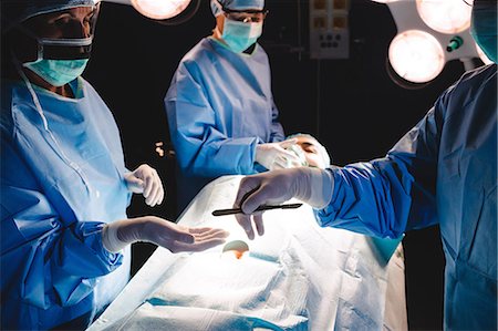 simsearch:6109-08720095,k - Surgeons giving operation blade to colleague in operation room at hospital Stock Photo - Premium Royalty-Free, Code: 6109-08720183