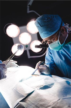 simsearch:6109-08830140,k - Surgeons performing operation in operation room at the hospital Foto de stock - Sin royalties Premium, Código: 6109-08720181