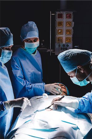 simsearch:6109-08829999,k - Surgeons performing operation in operation room at the hospital Foto de stock - Sin royalties Premium, Código: 6109-08720184