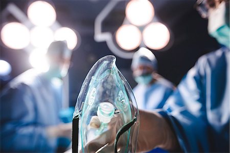 simsearch:6109-08720095,k - Surgeon holding oxygen mask in operation room at hospital Stock Photo - Premium Royalty-Free, Code: 6109-08720186